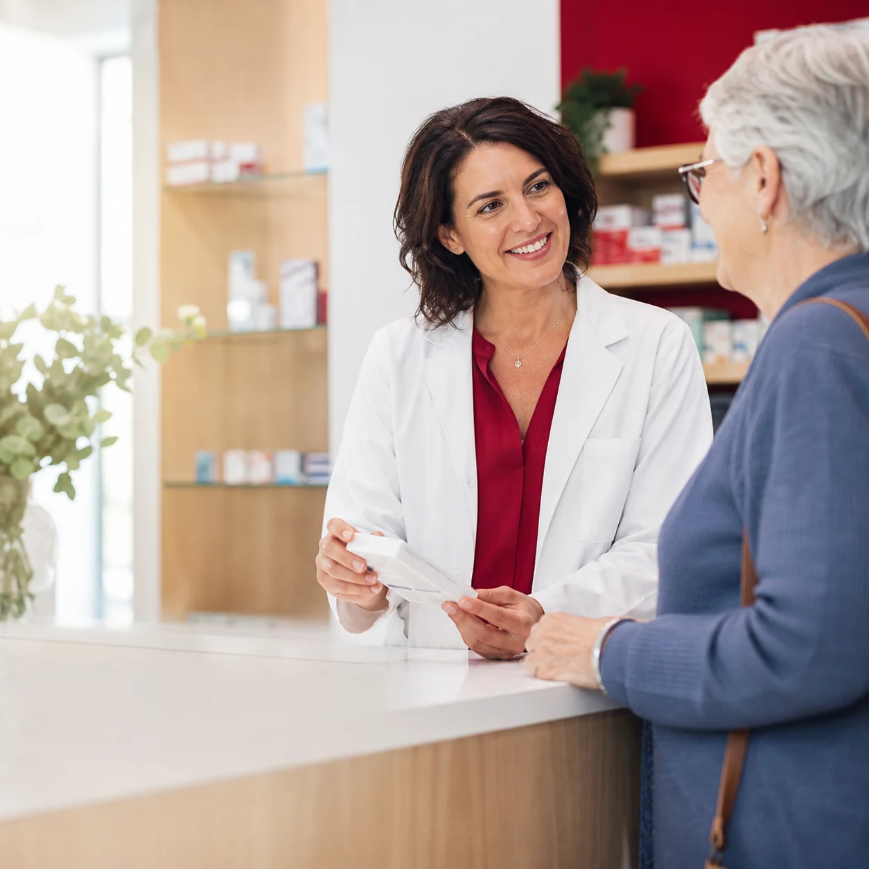 A pharmacist helping a senior customer at the consultation counter
